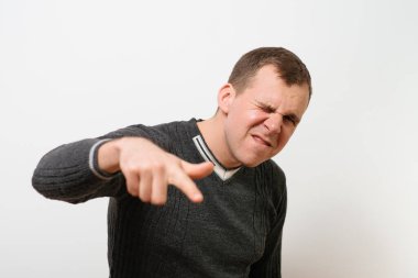 Genç adam işaret parmağını kameraya doğru gösteriyor.