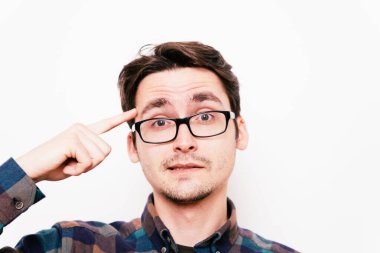 Parmağıyla şakağına dokunan öfkeli bir adamın yakın plan portresi. Delirdin mi sen??