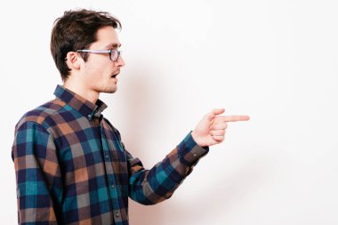 Yakından bakınca genç bir adamın portresi, birini ya da bir şeyi işaret ediyor. Olumlu insan yüzü ifadeleri, duygular, duygular, tutum, yaklaşım