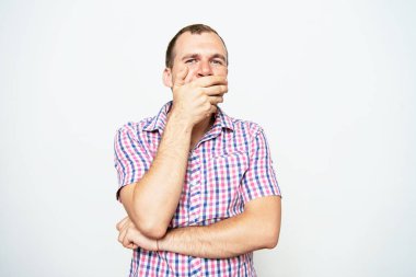 Adam gülüyor ve ağzını kapatıyor.