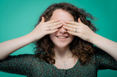 Kadın elleriyle gözlerini kapatıyor.