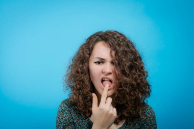 Stüdyo arka planında dil gösteren kadın