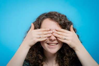 Kadın elleriyle gözlerini kapatıyor.