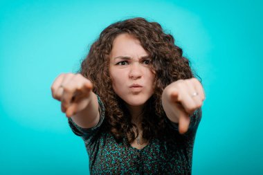 Kızgın kadın birini azarlıyor ve parmağını kameraya doğrultuyor.