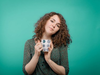 Stüdyo arka planında fincan olan kadın.