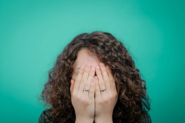  Kadın elini yüzünü kapatıyor.