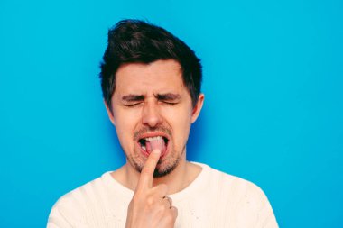 Avrupa görünümlü bir erkek kusmaya neden olur. Parmaklarını ağzına koyar, mide bulantısı.