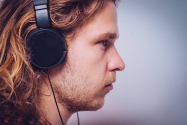 Kulaklıklı bir adam stüdyo geçmişine karşı. 