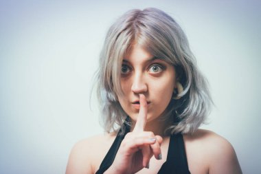 Kadın parmağını dudaklarına koydu.