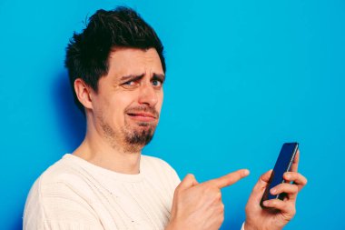 Stüdyo geçmişine karşı akıllı telefonu olan bir adam. 