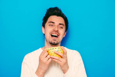 Stüdyonun arka planında fincan olan adam 