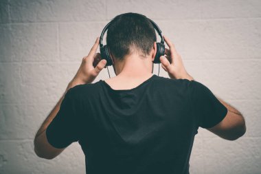 Kulaklıklı bir adam stüdyo geçmişine karşı.