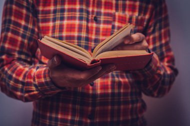 Elinde kitap olan adam.