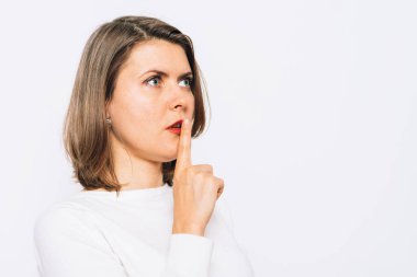 Kadın parmağını dudaklarına koydu.