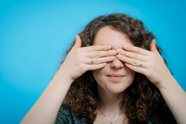 woman closes eyes with her hands