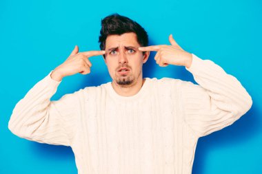 Parmağıyla şakağına dokunan öfkeli bir adamın yakın plan portresi. Delirdin mi sen??