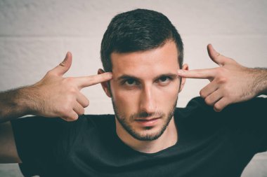 Parmağıyla şakağına dokunan öfkeli bir adamın yakın plan portresi. Delirdin mi sen??