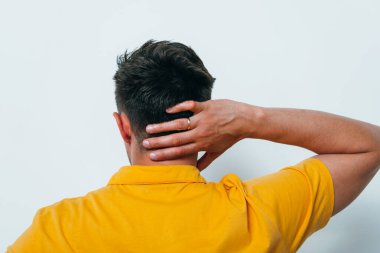 Kafasını tutarak. Arkadaki adam