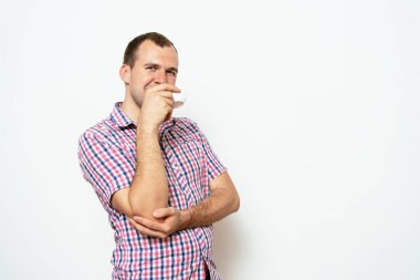 Stüdyonun arka planında fincan olan adam