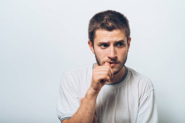 Adam tırnaklarını stüdyonun arka planında yiyor.