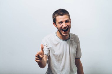 Genç adam işaret parmağını kameraya doğru gösteriyor.