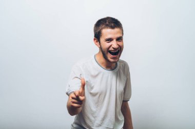 Genç adam işaret parmağını kameraya doğru gösteriyor.