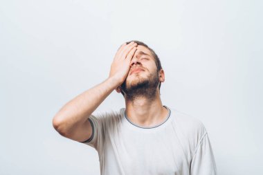  Adam elleriyle yüzünü kapatıyor.