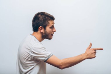 Yakından bakınca genç bir adamın portresi, birini ya da bir şeyi işaret ediyor. Olumlu insan yüzü ifadeleri, duygular, duygular, tutum, yaklaşım