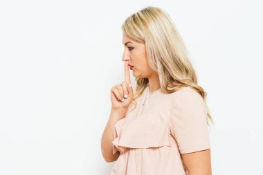 Kadın parmağını dudaklarına koydu.