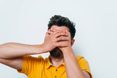 Adam elleriyle yüzünü örttü.