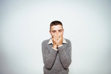 Adam gülüyor ve ağzını kapatıyor.