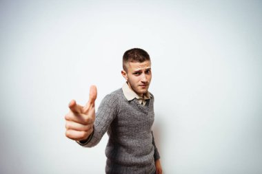 Genç adam işaret parmağını kameraya doğru gösteriyor.