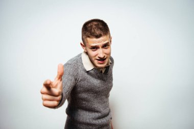 Genç adam işaret parmağını kameraya doğru gösteriyor.