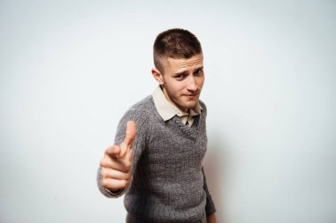 Genç adam işaret parmağını kameraya doğru gösteriyor.