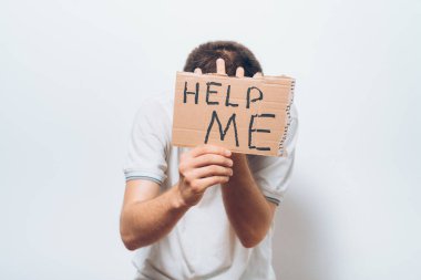 İçinde yardım mesajı olan bir karton. Gri bir arkaplanda.