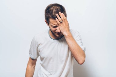  Adam elleriyle yüzünü kapatıyor.