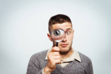 Elinde büyüteç olan adam.