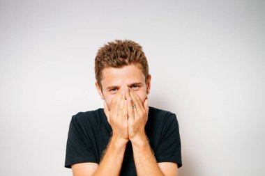 Adam gülüyor ve ağzını kapatıyor.