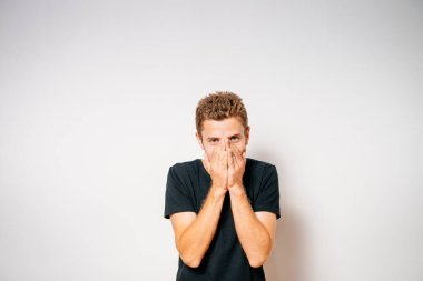 Adam gülüyor ve ağzını kapatıyor.