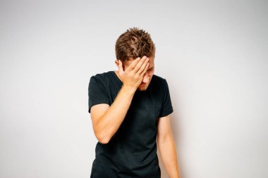  Adam elleriyle yüzünü kapatıyor.