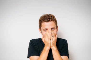 Adam gülüyor ve ağzını kapatıyor.