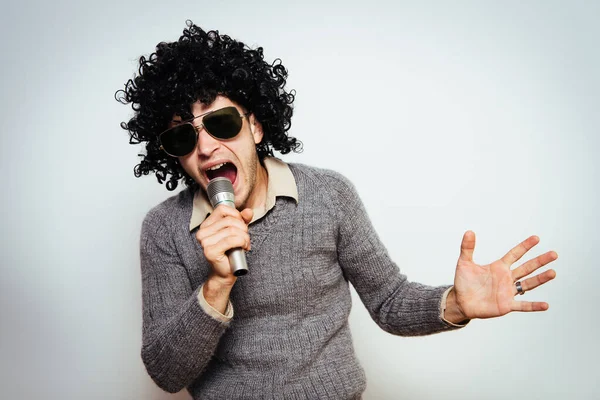 Egy Férfi Parókában Egy Napszemüveg Mikrofonba Énekelve — Stock Fotó