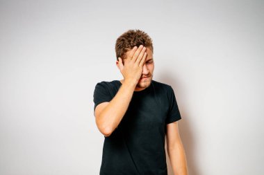  Adam elleriyle yüzünü kapatıyor.