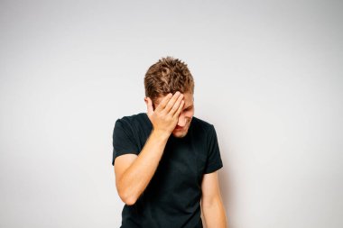  Adam elleriyle yüzünü kapatıyor.