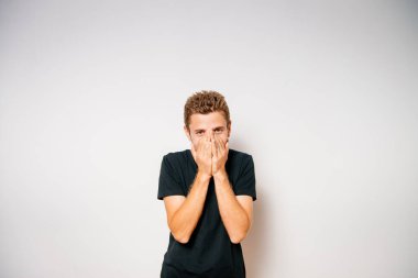 Adam gülüyor ve ağzını kapatıyor.