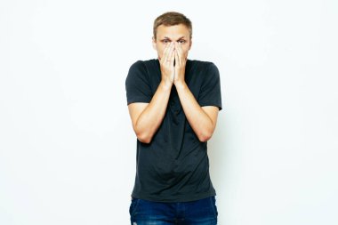 Adam gülüyor ve ağzını kapatıyor.