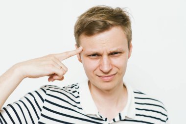 Parmağıyla şakağına dokunan öfkeli bir adamın yakın plan portresi. Delirdin mi sen??