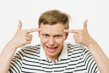 Parmağıyla şakağına dokunan öfkeli bir adamın yakın plan portresi. Delirdin mi sen??