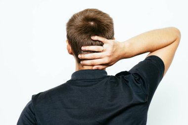 Kafasını tutarak. Arkadaki adam