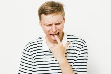 Avrupa görünümlü bir erkek kusmaya neden olur. Parmaklarını ağzına koyar, midesi bulanır.